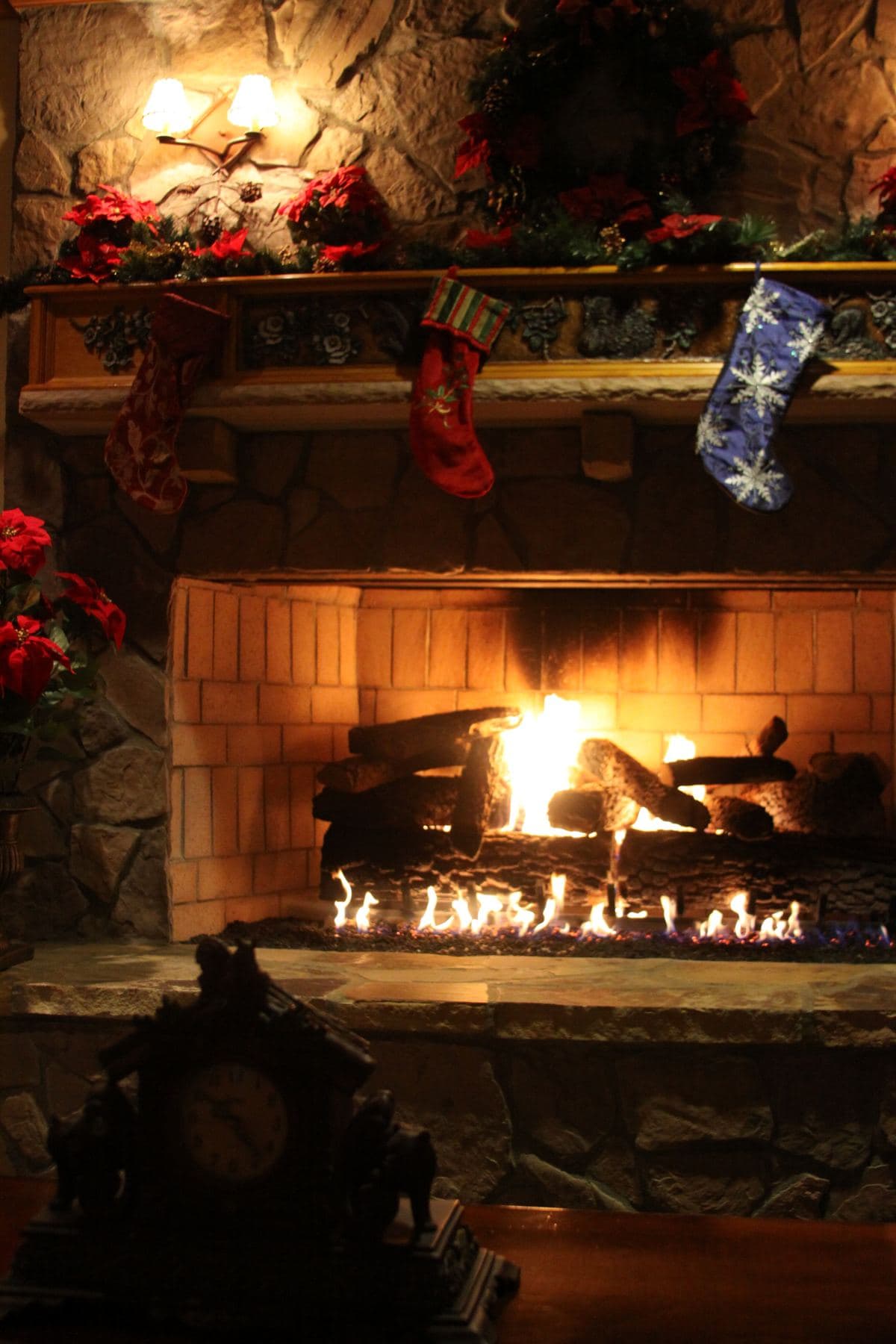 A stone fireplace decorated for Christmas
